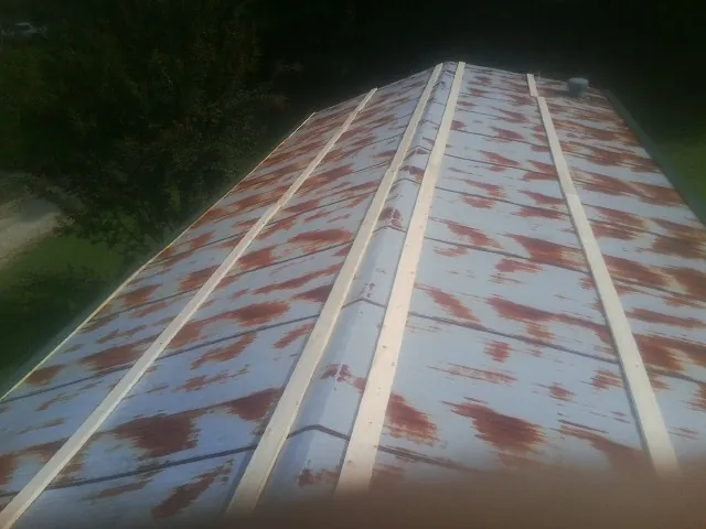 Rusted metal roof panels with new wood purlins before replacement — Storm Damage Roof Repair in Kirksville by Roofing Brothers