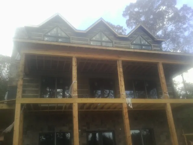Dormers and porch framing on a large log home under construction — Roof Coating work by our crew in Kirksville