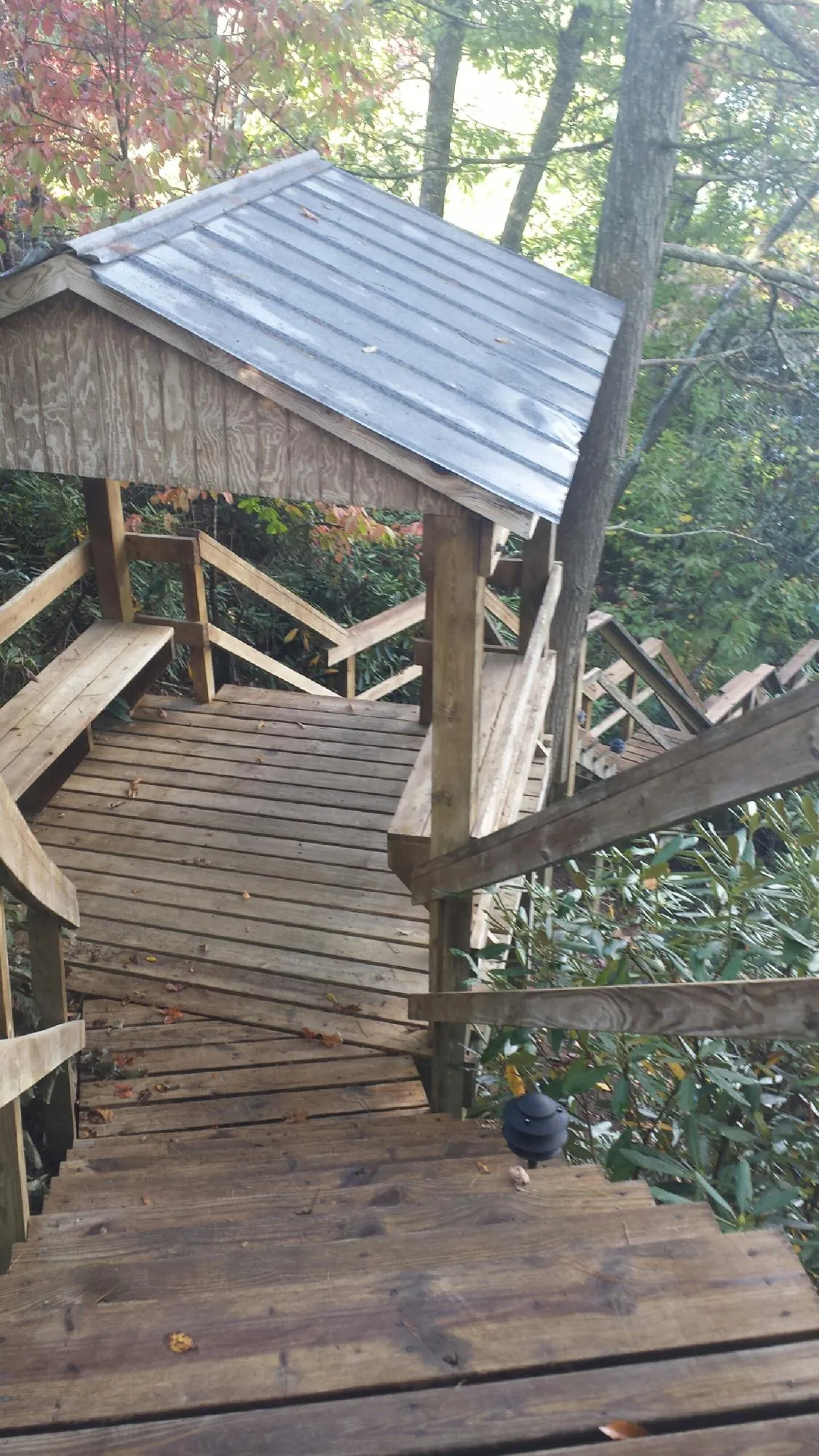 Metal roofed shelter over wooden steps on a wooded walkway — Skylight Repair & Installation work by our crew in Kirksville