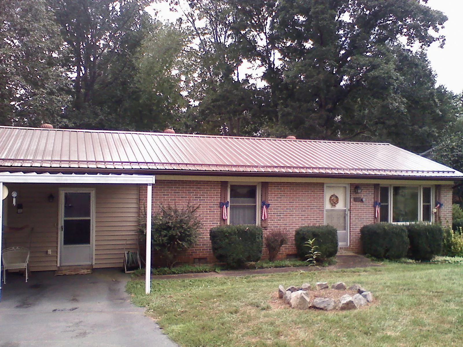 Bronze metal roof and carport on a brick ranch home — Roof Repair work by our crew in Kirksville